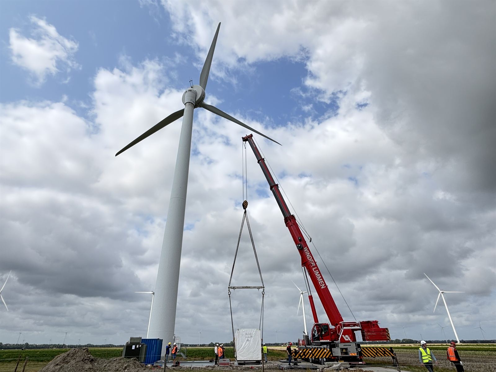 Een batterijcontainer wordt met een kraan op de fundering geplaatst