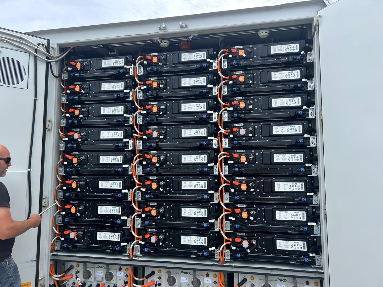Geopende batterijcontainer met rekken vol batterijmodules en bekabeling