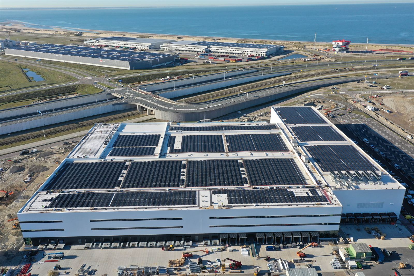 Plat dak van een distributiecentrum, in vakken belegd met rijen zonnepanelen